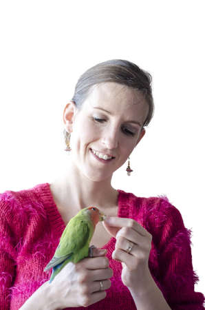 Young woman holding her pet- a green Lovebird parrot  Isolated over white background の写真素材