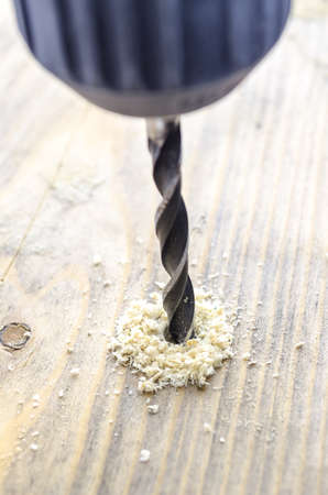 Closeup of drilling a hole in a wooden plank の写真素材