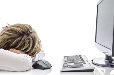 Tired man sleeping at his office desk in front of computer の写真素材