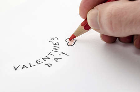 Male hand writing a Valentines day message on a white paper の写真素材