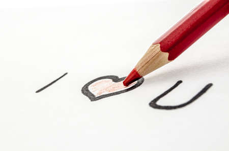 Painting a heart with I love you message on a white paper の写真素材