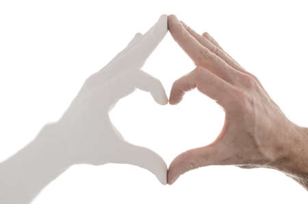 Making a heart shape with reflection of a hand  Isolated over white background の写真素材