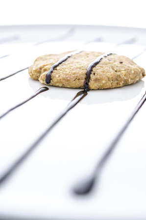 Homemade cookie on a white plate decorated with chocolate. Selective focus.の写真素材