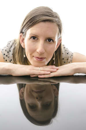 Portrait of a smiling girl leaning on a table with reflection 