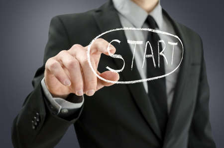 Business man pressing start button on a virtual board の写真素材