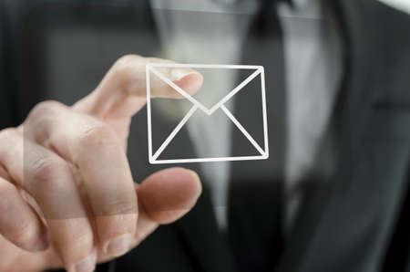 Businessman touching email icon on a virtual screen の写真素材