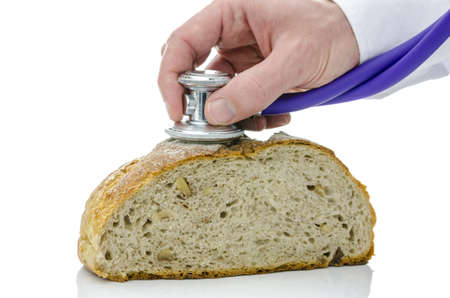 Male hand holding stethoscope on a buckwheat bread  Isolated on white background 