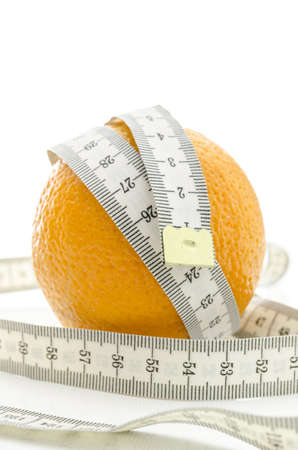 Fresh orange with white measuring tape wrapped around it  Over white background の写真素材