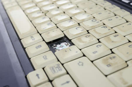 Closeup of and old and dirty laptop keyboard missing a key 