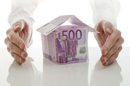Male hands giving energy to money house  Concept of real estate crisis solution の写真素材