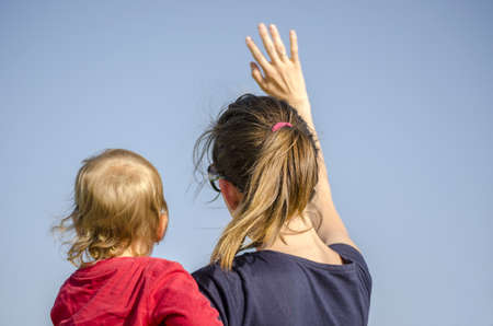 Mum and son waving  View from behind の写真素材