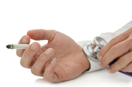 Stethoscope on male hand holding a cigarette  Help for cigarette addicts  With copy space  の写真素材