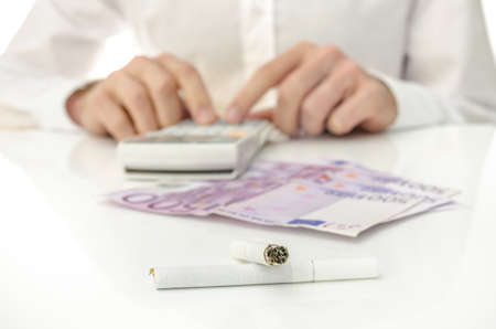 Man calculating monthly costs of cigarette addiction.の写真素材