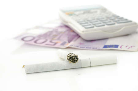 Cigarettes with Euro money and calculator in background. Concept of costs of smoking.の写真素材