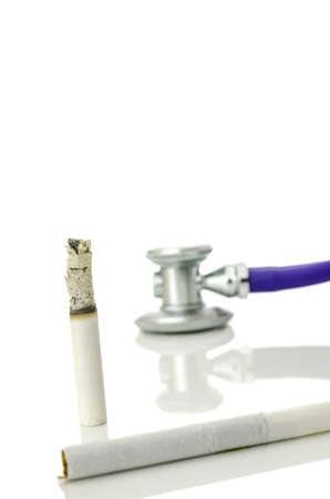 Half burned cigarette with stethoscope in background.の写真素材