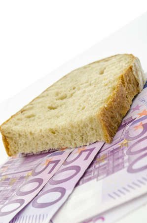 Piece of brad on Euro banknotes. Concept of large food expenses.の写真素材
