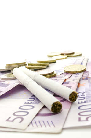 Cigarettes on Euro banknotes representing how expensive smoking habit is.の写真素材