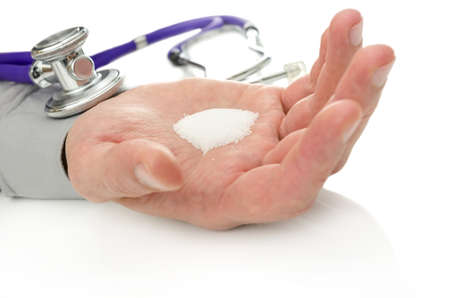 Stethoscope on hand holding white sugar. Diabetes concept.の写真素材
