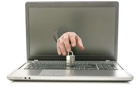 Front view of hand coming out of laptop screen trying to steal or break a padlock on keyboard.