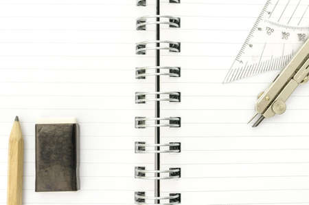 Closeup of various school supplies on open spiral notebook.