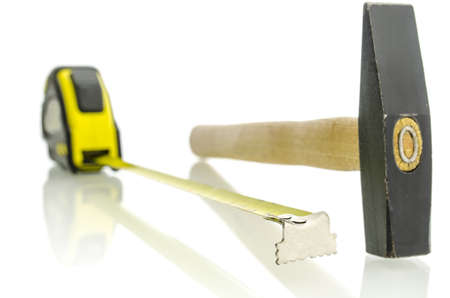 Tape measure and hammer on white desk with reflection  の写真素材