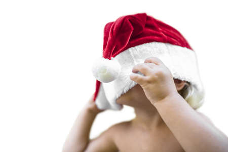 Baby with oversized red santa hat. Isolated over white background.の写真素材