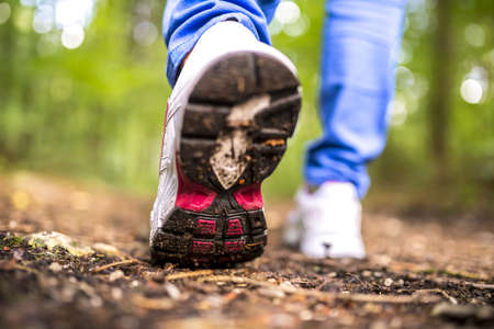 Detail of walking in the woods. Closeup of womans step.