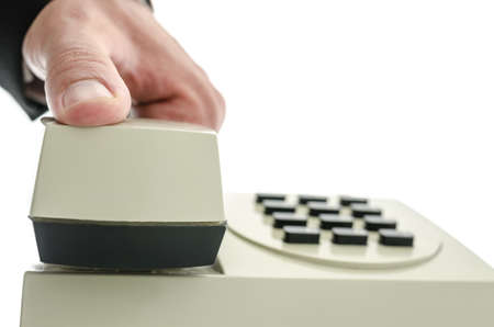 Closeup of businessman hand holding telephone receiver as if he is picking or hanging up the phone. Isolated over white background.の写真素材