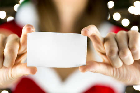 Closeup of miss Santa holding blank greeting card. Empty space ready for your text or logo.の写真素材
