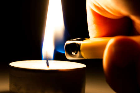 Closeup of lighting a tee candle with a lighter.の写真素材