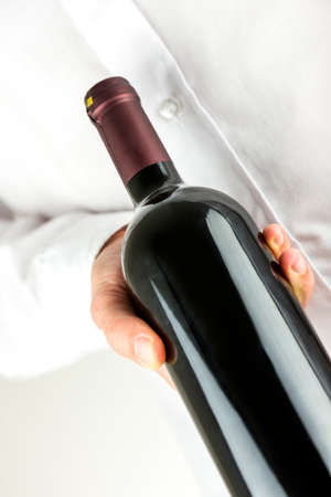 Closeup of waiter offering a bottle of wine.の写真素材