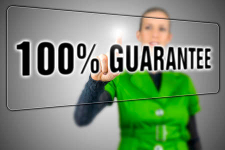 Woman pressing 100 percent guarantee button on virtual screen.の写真素材