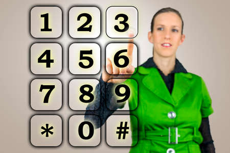 Woman with a numeric keypad on a virtual interface raising her finger to activate a numeral on the...