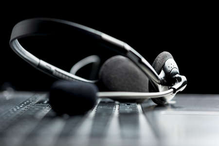 Headset lying on a laptop computer keyboard conceptual of online communication or a call centre, low angle viewの写真素材
