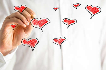 Hand-drawn hearts on a Valentines greeting card design in a random scattered pattern with copyspace for your message to your sweetheartの写真素材