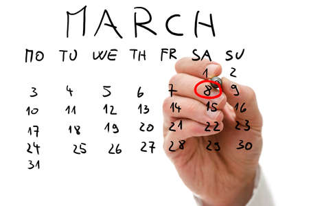 Male hand marking on a monthly calendar, placed on a virtual screen, the date of March 8, International Women's Day or Mother's Day.の写真素材