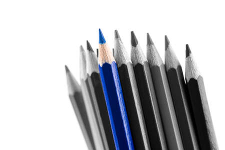 Pile of sharp colored pencils, with different hues, from black to light grey and a blue outstanding one, close-up on white .の写真素材