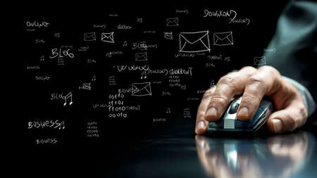 Close up view of the hand of a businessman using a computer mouse on a reflective black surface with...
