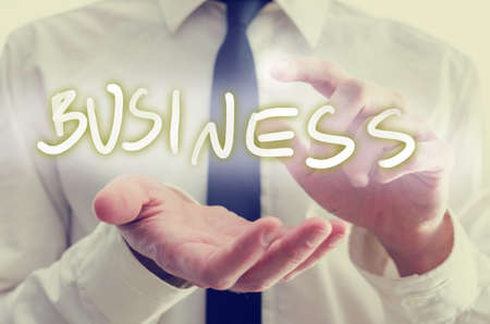 Business startup concept with the hands of a businessman reaching out to protect and activate the...