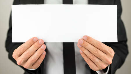 Businessman holding blank paper ready for your text or letters.の写真素材