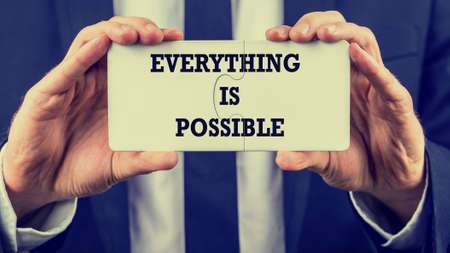 Retro style image of a businessman holding two joined jigsaw puzzle pieces with phrase の写真素材