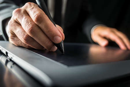 Closeup of graphic designer using digital tablet to do his work.の写真素材