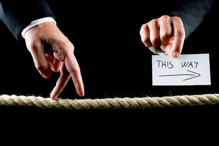 Metaphoric image of male hand walking on frayed rope towards success.の写真素材