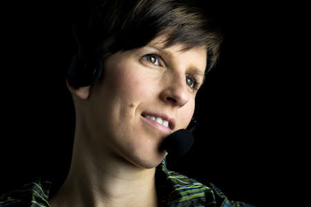 Beautiful young woman wearing a headset staring into the distance with a pensive expression の写真素材