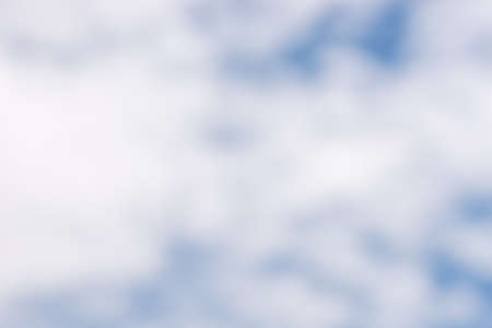 Blurred cloudscape background with soft white clouds in a blue sky conceptual of the weather, nature and the environment.の写真素材