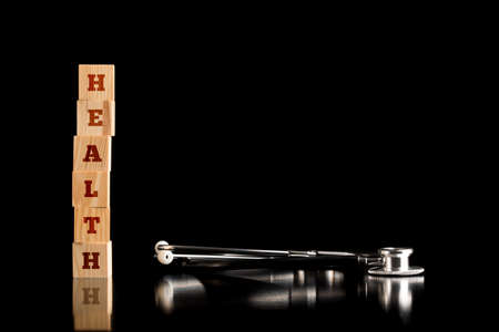Health concept with copy space with a stacked tower of wooden blocks with the word - Health - on a...