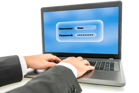 Businessman logging in on a laptop computer with the screen requesting his username and password as...