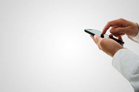 Man surfing the internet or making a call on a smartphone navigating the touchscreen with his finger...