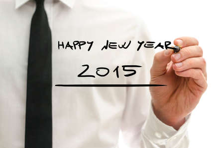 Man writing Happy New Year 2015 on a virtual interface with copyspace over the white of his shirt...