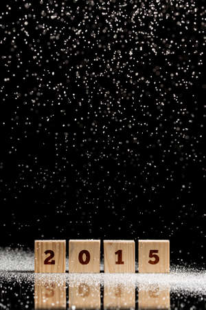 Attractive Falling Snow Particles on Small Wooden Blocks with 2015 Text on Black Background.の写真素材